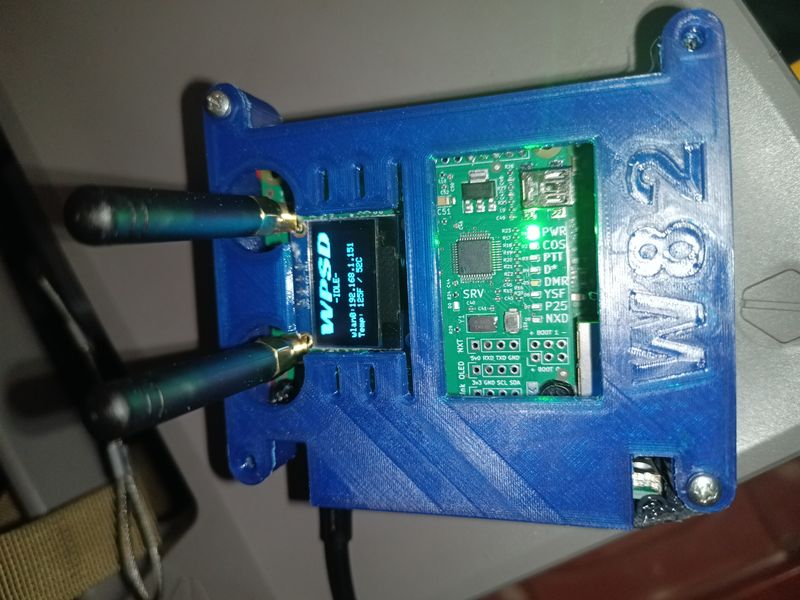 The hotspot in its blue 3D-printed case, with two antennas, the small screen and the radio board visible