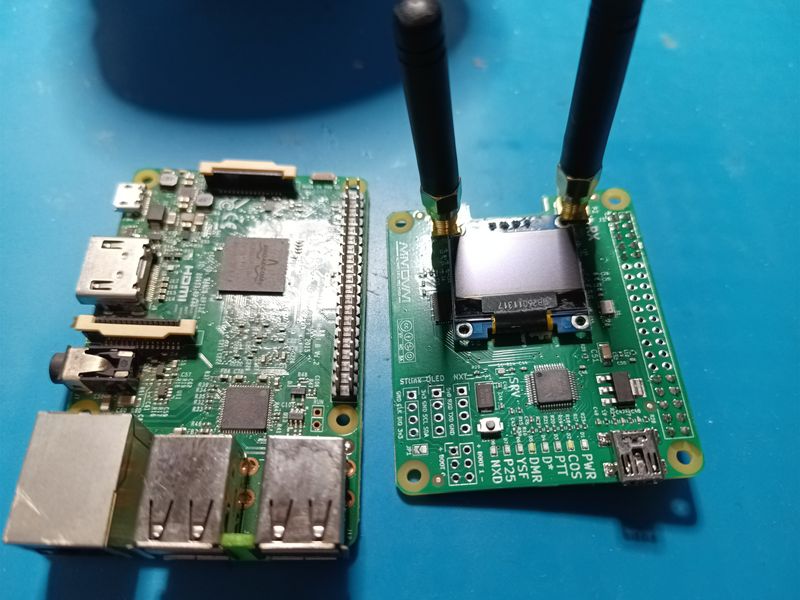 The radio board with antennas lying next to a Raspberry Pi 3B