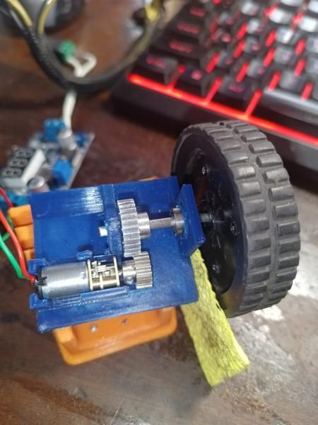 An N20 gearmotor in a blue 3D-printed test mount driving a small wheel
