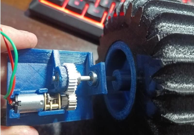 The motor gearbox held next to a printed tyre